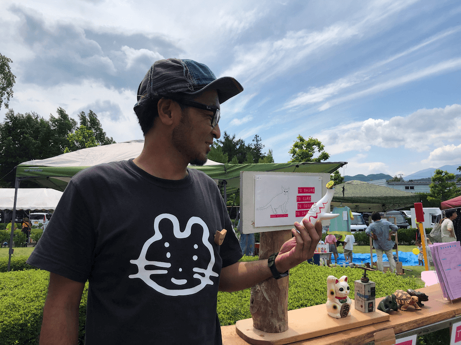 早坂健一（Kenichi Hayasaka）氏 ニャードセール主催者 / 宮城県塩釜市出身。20歳の時に就職とともに東京に出て、沖縄に4年、横浜に2年、鎌倉に6年、仙台に2年暮らしたのち、宮城県川崎町へ移住。今回取材に訪れた際には、主催するフリーマーケット「ニャードセール」を町内の方を巻き込んで実施していた。ニャードセールの主催者としての顔以外に、建物管理者としての顔や、ミュージシャンとしての顔も持つ。