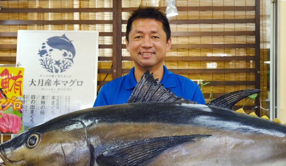 新谷文彦（Fumihiko Niiya）さん マグロ推進協議会会長 / 両親ともに大月町民の純血大月町民。デザインを学ぶため上京。5年の都会暮らしを経て理由もなく帰郷。地元でホテルマンとして約8年勤め、異動により道の駅大月へ。道の駅大月で働くことにより、農業・漁業・加工業を学ぶ。