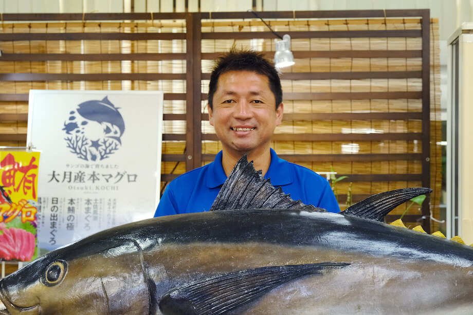 新谷文彦（Fumihiko Niiya）さん マグロ推進協議会会長 / 両親ともに大月町民の純血大月町民。デザインを学ぶため上京。5年の都会暮らしを経て理由もなく帰郷。地元でホテルマンとして約8年勤め、異動により道の駅大月へ。道の駅大月で働くことにより、農業・漁業・加工業を学ぶ。