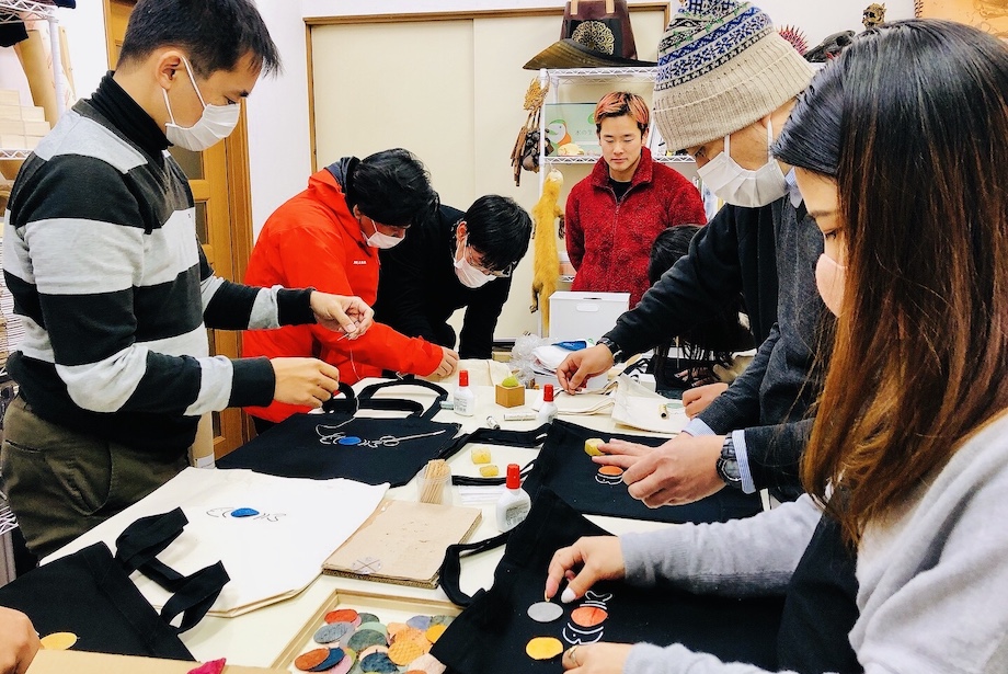 「トートバック」か「缶バッチ」を選び、実際にフィッシュレザーを使った小物を作ります。フィッシュレザーの模様も色も、唯一無二のデザインだからこそ、全員がめちゃくちゃ悩む。「40分もあれば余裕で終わる」と聞いていたワークショップでしたが、結局60分没頭する結果に。笑