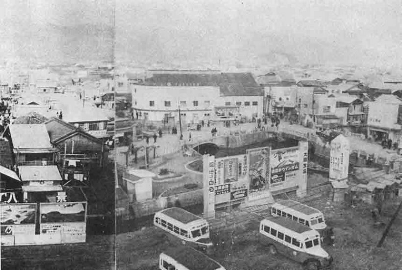 昭和25年1月の頃の新京橋・使者屋橋付近。大丸の位置に映画館があり、電車通り拡幅前なのでバスの駐車場が手前に見える「高知市戦災復興史」高知市